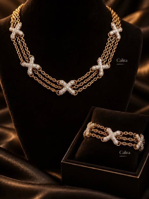 Conjunto de colar e pulseira dourados da Calira, com a pulseira na caixa assinada da marca